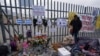 Un altar con velas y fotos cubre la cerca afuera del centro de detención de migrantes que fue el sitio de un incendio en que murieron unas 40 personas, en su mayoría guatemaltecos, el 30 de marzo de 2023. 