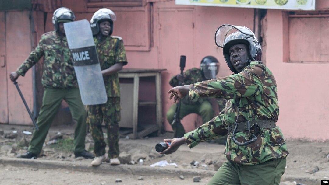 A Kenyan police officer throws a tear gas canister during anti-government protests in Nairobi on July 20, 2023.