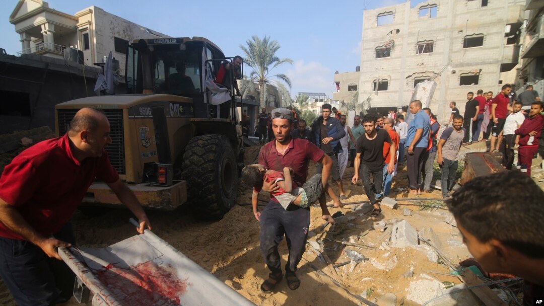 Palestinians pull a boy from the rubble after an Israeli strike on the Zaroub family house in Rafah, Gaza Strip, Oct. 24, 2023.