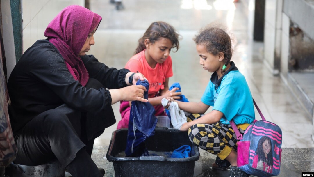 가자지구 중부 데이르 알-발라에서 팔레스타인 난민 가족이 유엔 팔레스타인난민구호기구(UNRWA) 산하 학교 부근 피난처에서 빨래를 하고 있다.