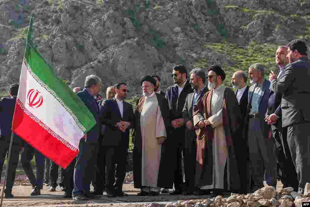 A handout picture provided by the Iranian presidency shows Iran's President Ebrahim Raisi (C) at the site of Qiz Qalasi, the third dam jointly built by Iran and Azerbaijan on the Aras River, ahead of its inauguration ceremony, May 19, 2024.