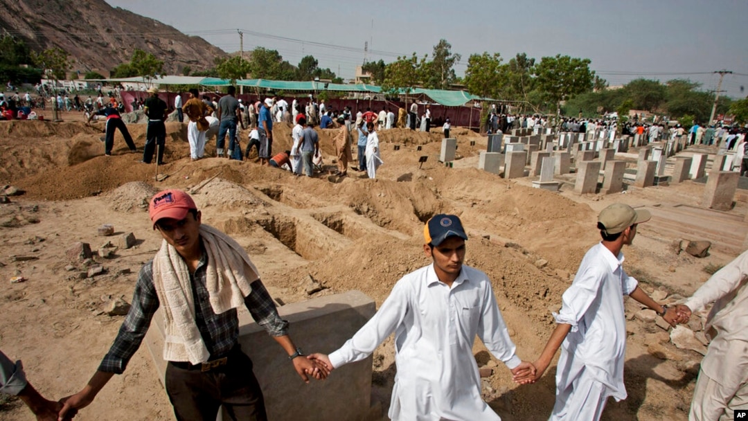 FILE - People from the Muslim Ahmadi community stand guard as others prepare to bury victims of attack by Islamic militants, in Rubwah, Pakistan, 29, 2010. The Ahmadis have recorded nearly three dozen attacks on their places of worship so far in 2023.