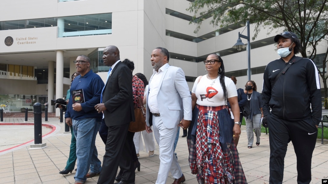 FILE - Attorney Ben Crump, second from left, walks with Ron Lacks, left, Alfred Lacks Carter, third from left, both grandsons of Henrietta Lacks, and other descendants of Lacks, outside the federal courthouse in Baltimore, Oct. 4, 2021. 