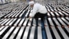 FILE - This photo taken March 12, 2021, shows a worker with car batteries at a factory for Xinwangda Electric Vehicle Battery Co. Ltd., which makes lithium batteries for electric cars and other uses, in Nanjing, Jiangsu province, China. 