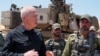 FILE - Israeli Defense Minister Yoav Gallant stands with soldiers by a self-propelled artillery howitzer during a visit to a position along the border with the Gaza Strip in southern Israel near Rafah, May 7, 2024. (Photo by Israeli Army/AFP) 