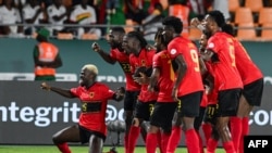 O avançado angolano #9 Zini celebra com os colegas de equipa depois de marcar o segundo golo da sua equipa durante o jogo de futebol do grupo D da Taça das Nações Africanas (CAN) 2024 entre Angola e o Burkina Faso a 23 de janeiro de 2024