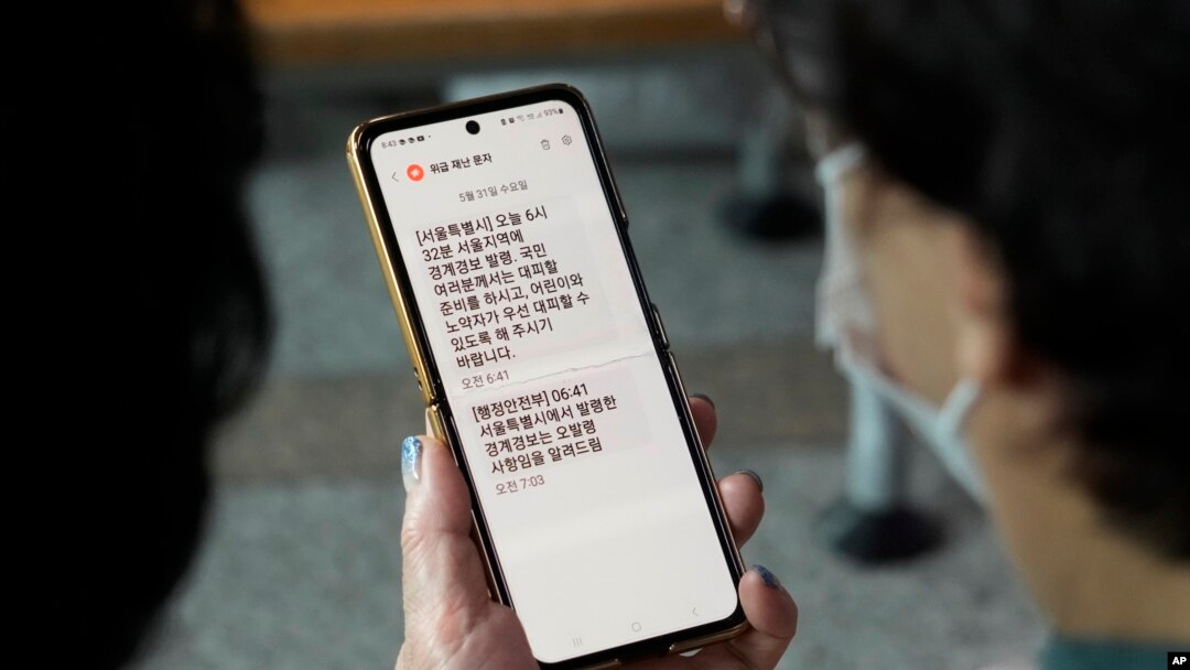 Yon dam gade telefon ni, ki aveti sitwayen nan vil Seoul pou yo evakye, depi yon stasyon tren nan vil Seoul, kapital Kore di Sid, 31 Me, 2023. 