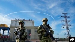 Quân đội Nga canh gác lối vào Thủy điện Kakhovka ở vùng Kherson, miền nam Ukraine, vào ngày 20/5/2022. Nga ra dấu về việc rút quân khỏi khu vực này nhưng Ukraine tỏ ra thận trọng trước thông tin này.