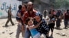 Palestinians run following what police said was an Israeli air strike on a house in Gaza city July 9, 2014. At least 23 people were killed across Gaza, Palestinian officials said.