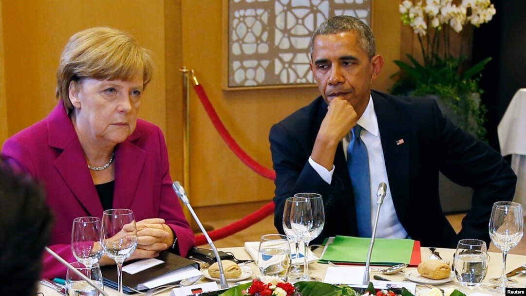 FILE - U.S. President Barack Obama (R) and German Chancellor Angela Merkel listen during the G7 Summit working dinner in Brussels.