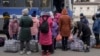 Children wait by bags with their belongings as they arrive at a train station to leave Kostiantynivka, Donetsk region, eastern Ukraine, Feb. 24, 2022.
