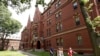 Des gens marchent le long d'un trottoir sur le campus de l'Université Harvard, à Cambridge, Mass., le 16 juillet 2019.