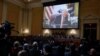 Members of the U.S. House Select Committee investigating the January 6 attack on the U.S. Capitol sit beneath an image showing former President Donald Trump in the Oval Office, at the U.S. Capitol in Washington, D.C., Dec. 19, 2022.