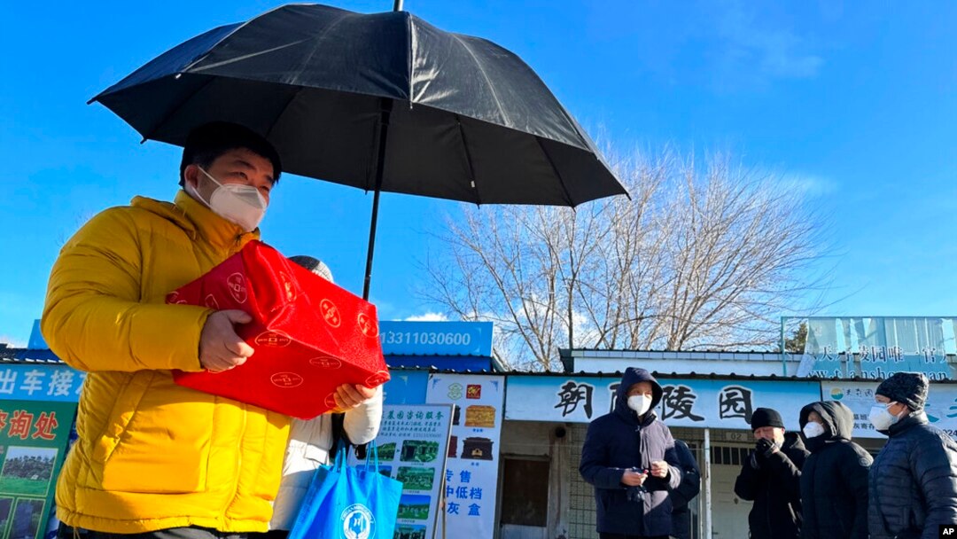 Family members collect the cremated remains of their loved one bundled with red cloth outside a crematorium in Beijing, Dec. 17, 2022.