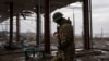 A Ukrainian serviceman patrols near the Antonovsky bridge, which was destroyed by Russian forces after withdrawing from Kherson, Ukraine, Dec. 8, 2022. 