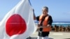 前東京都知事石原慎太郎在沖之鳥島上揮舞日本旗幟。（2005年5月20日）