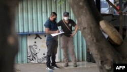 Police work at the scene where a man was killed by alleged gang members in Colón, La Libertad department, El Salvador, on March 26, 2022.