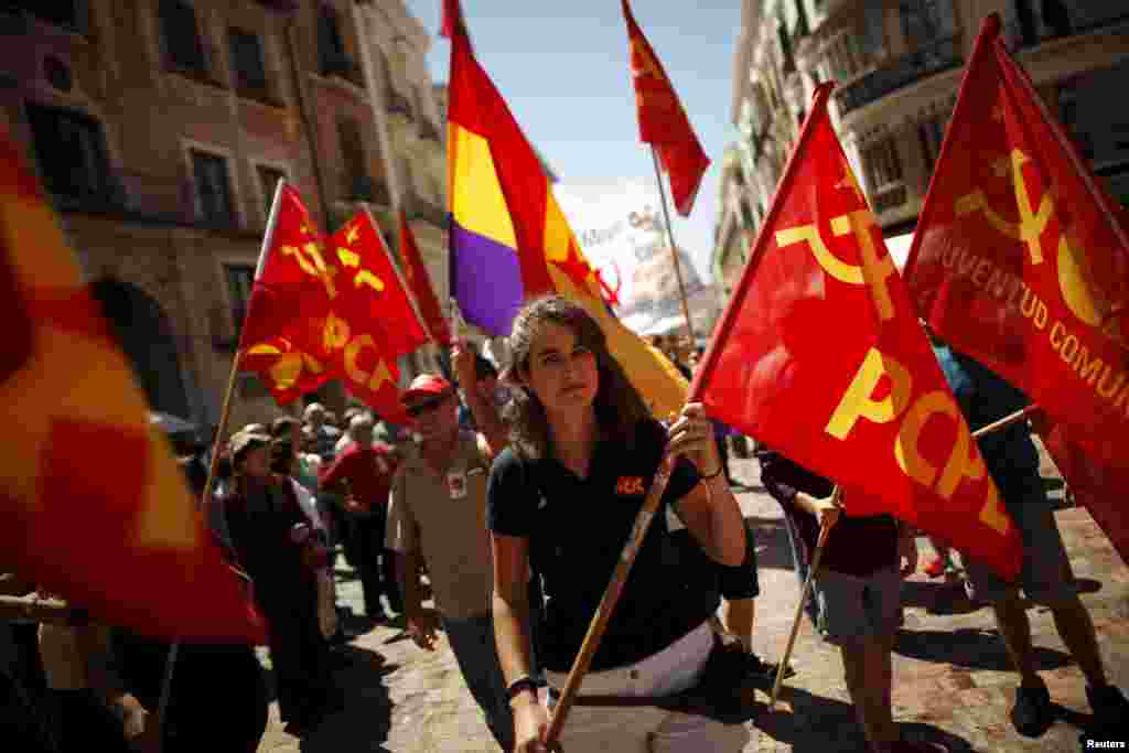 People wave a second Spanish Republic flag (C) and Communist flags during a May Day rally in Malaga, Spain, May 1, 2015.