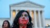 Une femme de Virginie porte des empreintes de mains rouges pour représenter la violence à l'égard des femmes, lors d'une manifestation devant la Cour suprême des États-Unis, le mardi 3 mai 2022, à Washington.