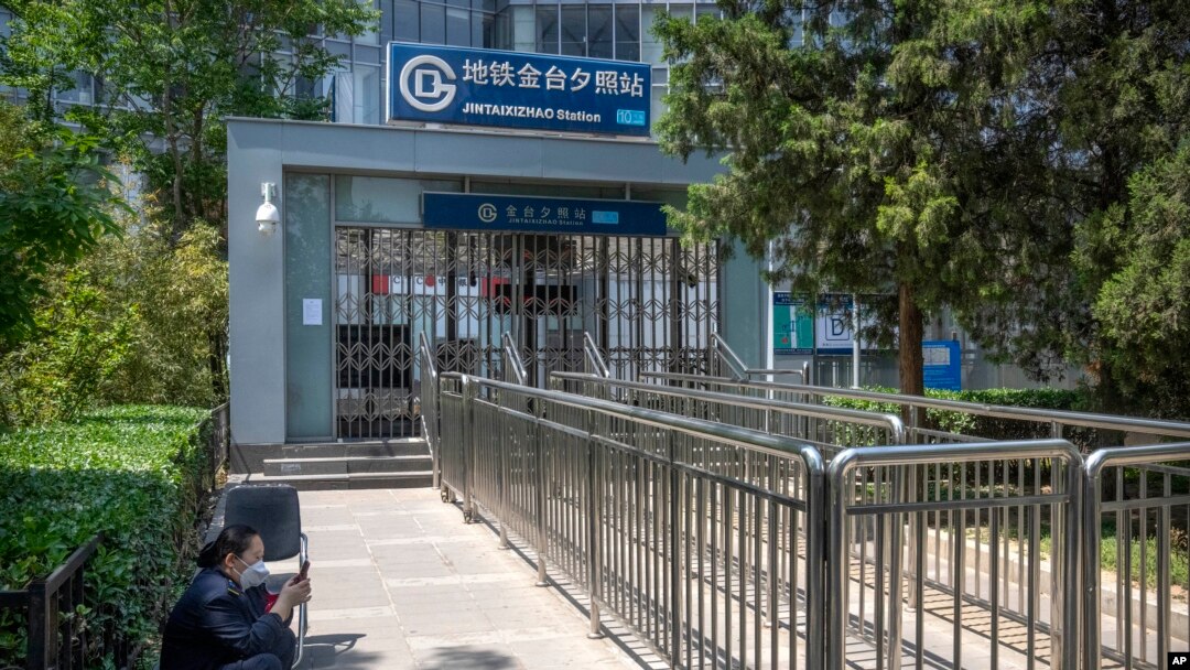 A worker sits near the closed exit of a subway station in Beijing, May 4, 2022. Shanghai has been under lockdown since late March to reduce the spread of COVID. Such restrictions have affected supply chains in such major areas.
