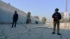 Security officials guard a blocked road leading to a counterterrorism center after security forces started to clear the compound seized earlier by Pakistani Taliban militants in Bannu, Pakistan, Dec. 20, 2022.