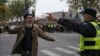 A protester holding flowers is confronted by a policeman during a protest on a street in Shanghai, China, Nov. 27, 2022. Authorities eased anti-virus rules in scattered areas but affirmed China's severe "zero-COVID" strategy Monday.