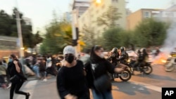 Wanawake wakikimbia askari wa kuzuia ghasia wakati wa maandamano ya kupiga serikali mjini Tehran. Picha hii imepigwa na mtu ambaye siyo mfanyakazi wa shirika la habari la AP, Septemba 19, 2022.