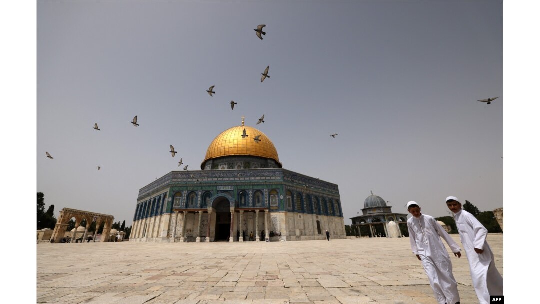 FILE - Palestinian Muslims walk in front of the Dome of Rock mosque at the Al-Aqsa mosque compound in Jerusalem's Old City, Apr. 17, 2022.