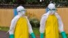 FILE - Health workers wearing protective gear go to remove the body of a person who is believed to have died after contracting the Ebola virus in Monrovia, Liberia, Aug. 16, 2014.