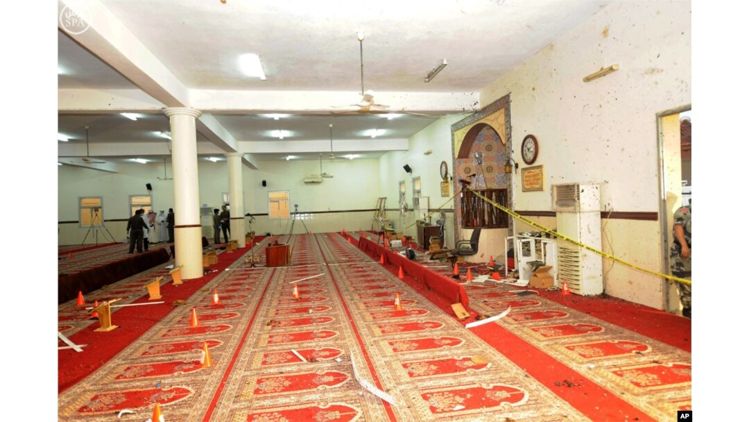 FILE - In this photo released by the Saudi Press Agency SPA, Saudi officials and investigators, background, check a mosque inside a police compound after a suicide bombing attack in of Abha, the provincial capital of Asir, Saudi Arabia, Aug. 6, 2015.