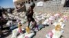 FILE - A Yemeni soldier, loyal to the Shi'ite Houthi movement, walks next to humanitarian aid supplies in a camp on the outskirts of the capital Sanaa, Yemen, March 16, 2017. 