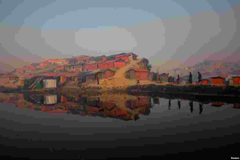Rohingya refugees walk by a pond at the Balukhali refugee camp near Cox's Bazar, Bangladesh.