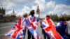 People walk over Westminster Bridge wrapped in Union flags, towards the Queen Elizabeth Tower (Big Ben) and The Houses of Parliament in central London on June 26, 2016. 