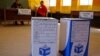 Ballot boxes await voters as Election officials (background) await their arrival after they opened early for disabled people to vote in Nyanga township before Wednesdays official elections on the outskirts of the city of Cape Town, South Africa, May 5, 2