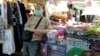 A vendor wears a face mask and waits for customers at a night market in Taipei, Taiwan, Thursday, Feb. 6, 2020.