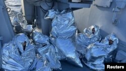 Grupa migranata umotanih u pokrivače za spasavanje, nakon što su spaseni iz voda oko ostrva Evija, Grčka, 1. novembra 2022.