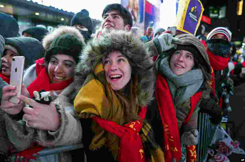 Revelers gathered on Times Square in New York watch the ceremonial ball rise to the top of a pole during New Year's Eve celebrations, Dec. 31, 2017.