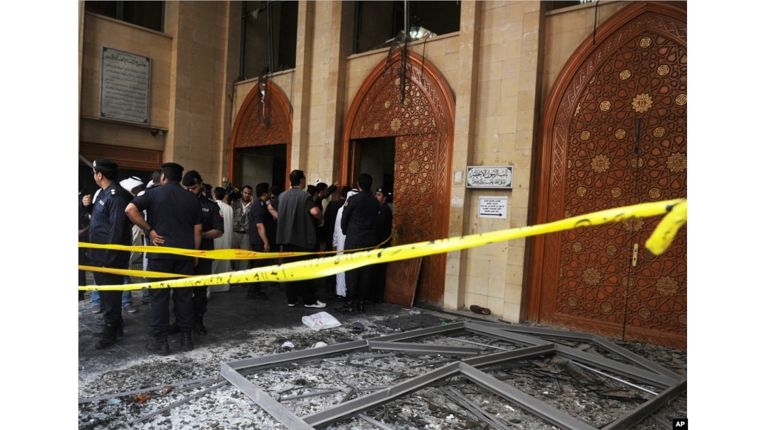 FILE - Security forces and officials gather at a Shi'ite mosque after a deadly blast claimed by the Islamic State group that struck worshipers attending Friday prayers in Kuwait City, June 26, 2015.