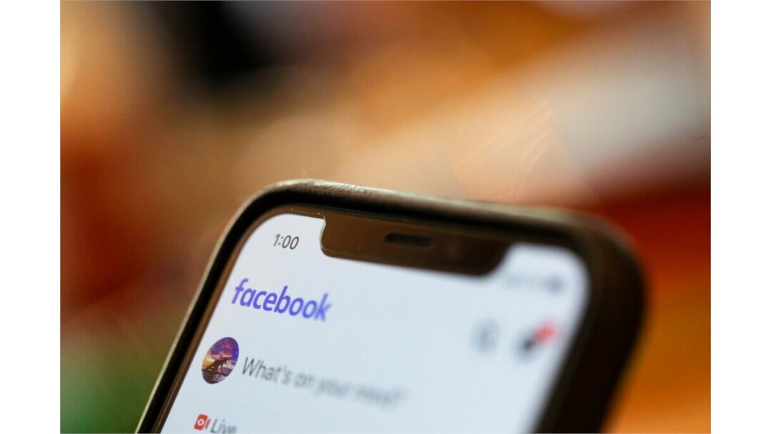 FILE - An iPhone displays a Facebook page, Aug. 11, 2019. Facebook said March 24, 2021, that hackers in China had used fake accounts and impostor websites in a bid to break into the phones of Uyghur Muslims.