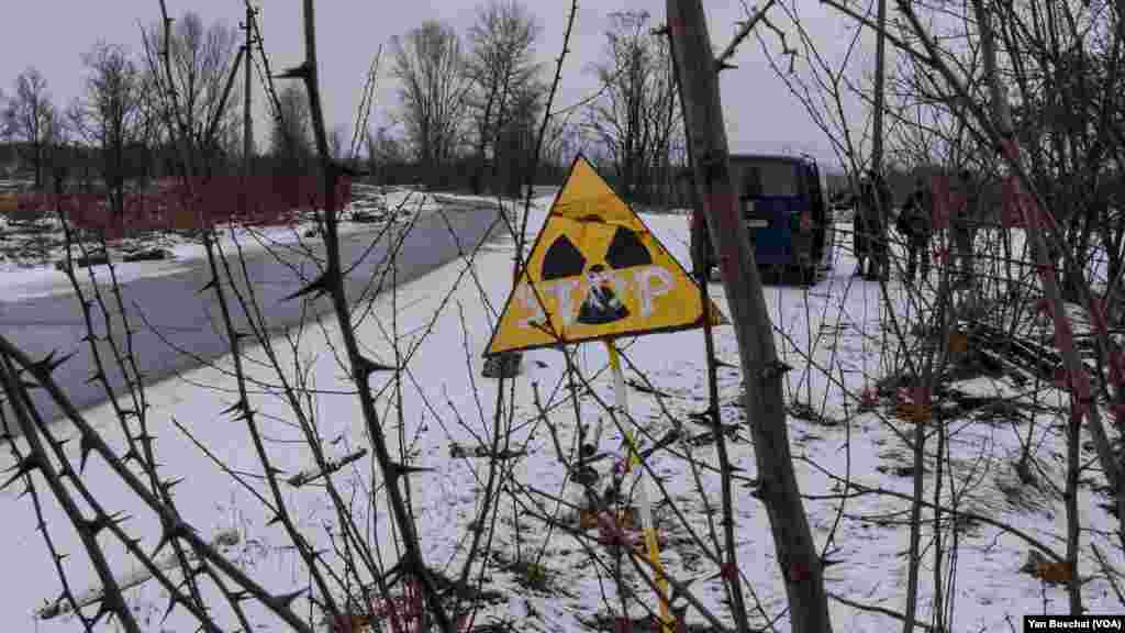 A sign showing that the levels of radiation might be high in this area marks the place where the Russians dug trenches and stablished a checkpoint in an area called the “red forest” in Chernobyl, Ukraine, on Jan. 31, 2023 (VOANEWS/Yan Boechat)