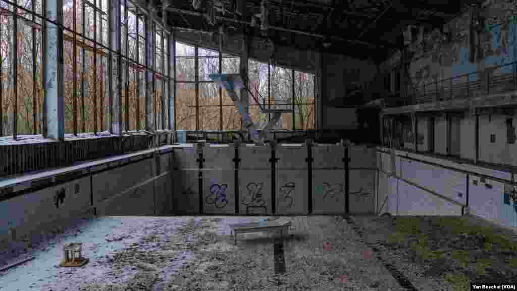 A deep dive pool inside one of the buildings in Prypiat that was abandoned after the explosion in 1986. All this area was occupied by Russian soldiers when they invaded Ukraine almost a year ago. In Chernobyl, Ukraine, Jan. 31, 2023 (VOANEWS/Yan Boechat)