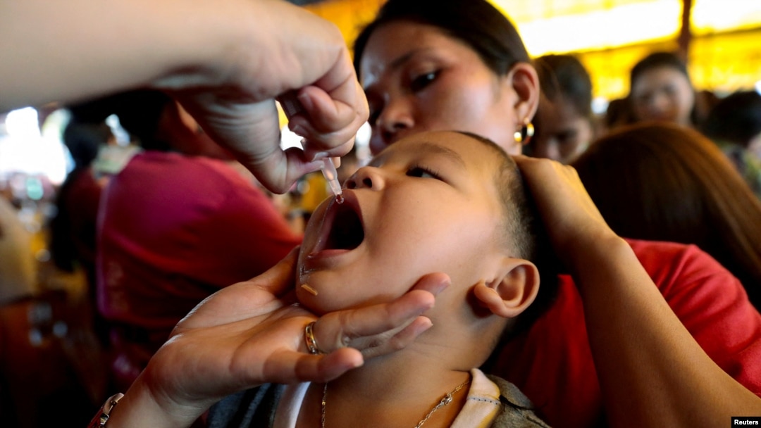 FILE - A child receives a free polio vaccine during a government-led mass vaccination program in Quezon City, Philippines, Oct. 14, 2019. 