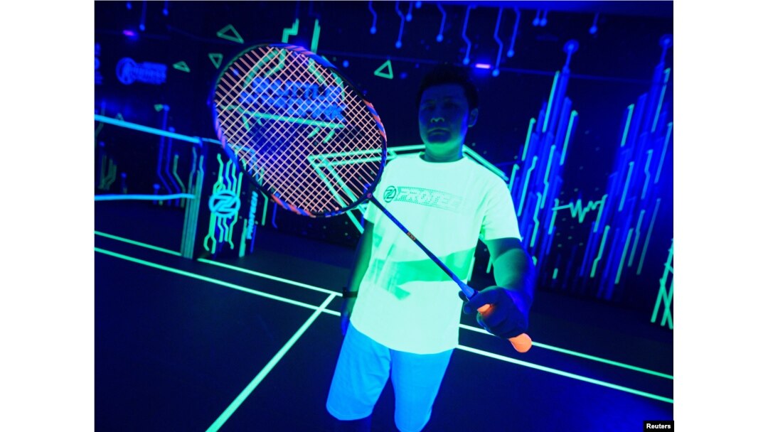 A badminton player shows his glow-in-the-dark badminton racket at a badminton court in Kuala Lumpur, Malaysia, March 24, 2022. (REUTERS/Hasnoor Hussain)