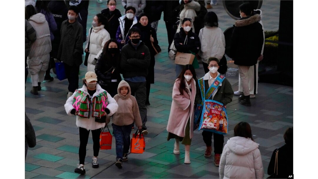 Shoppers return to a popular mall following the easing of pandemic restrictions in Beijing, Jan. 1, 2023.