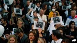 Personas sosteniendo una imagen del difunto fiscal antidrogas Marcelo Pecci, asisten a una reunión para exigir justicia por su asesinato, en Asunción, Paraguay, el 13 de mayo de 2022. 