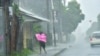 A woman fights gale force winds in the Indian Ocean Island of Mauritius, Feb. 2, 2022. Forecasts say Tropical Cyclone Batsirai is increasing in intensity and is expected to make landfall in central Madagascar on Feb. 5, 2022.