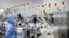 FILE - Employees wearing protective equipment work at a semiconductor production facility for Renesas Electronics during a government organized tour for journalists in Beijing, on May 14, 2020. 