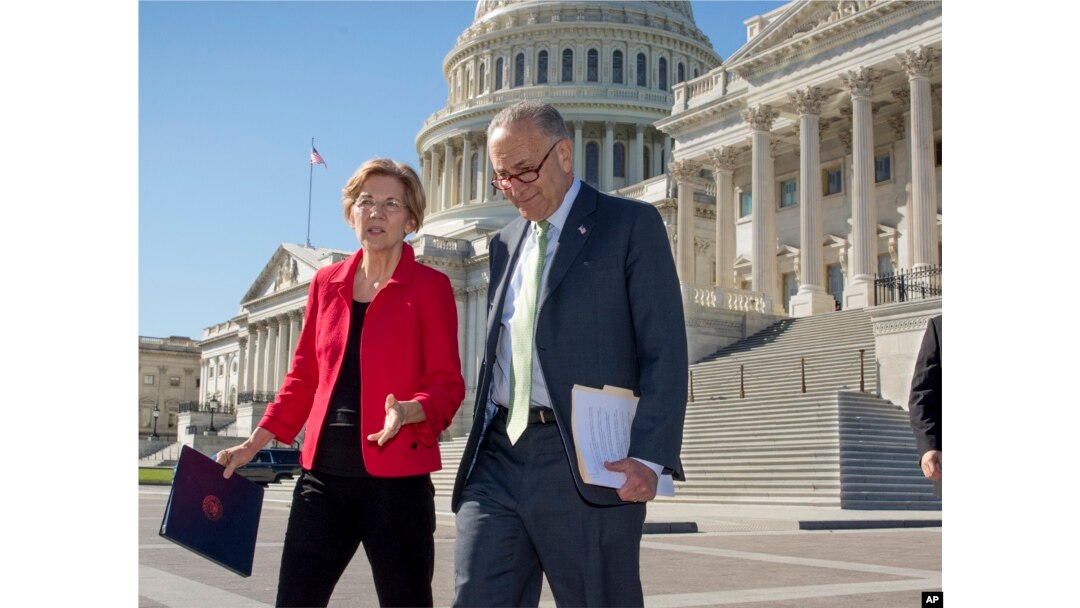 FILE - Senator Elizabeth Warren, D-Mass., left, and Senate Minority Leader Chuck Schumer, D-N.Y., walk to a news conference at the Capitol in Washington, Wednesday, Oct. 18, 2017.
