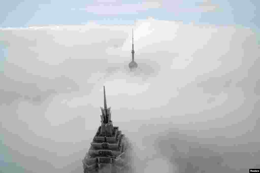 A pair of skyscrapers, Oriental Pearl Tower and Jin Mao Tower (front), are seen from the Shanghai World Financial Center on a cloudy day in the financial district of Pudong in Shanghai, China.