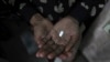 FILE - An AIDS patient in New Delhi, India, holds an anti-infectious drug.
